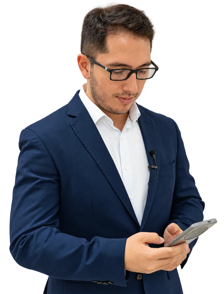 Andrés García-Umaña con chaqueta azul, consultando su teléfono